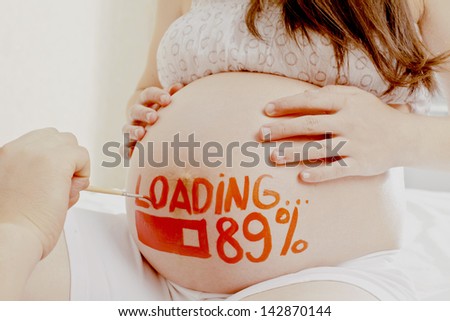 pregnant woman with painted husband on white paints watercolor brush word - loading - and figures 89%