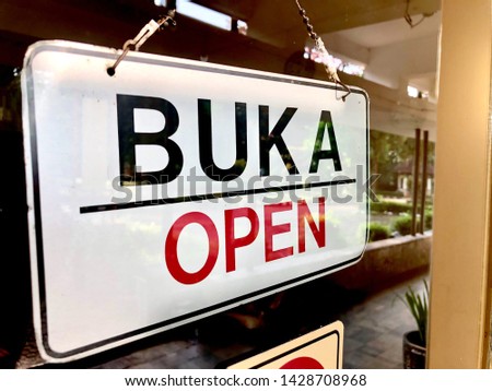 An open sign at the door with Indonesian language or Bahasa wording, BUKA. 