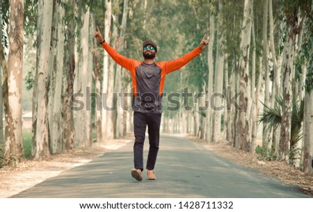 Man raising two hands walking in an empty road unique photo