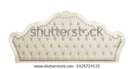 Shaped pastel beige color soft tufted leather capitone bed headboard of Chesterfield style sofa with carved wooden frame, isolated on white background, front view Royalty-Free Stock Photo #1428724535