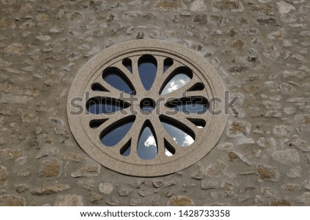 modern rosette on the outside of the wall of a church in Spain