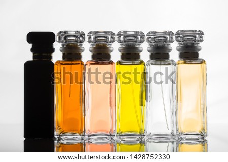 Glass bottles of perfume in a row on glass shelf 