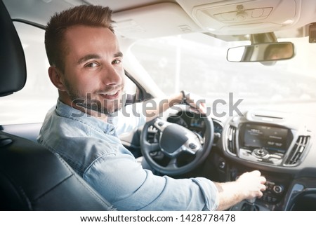 Young male driver behind the wheel. Sharing economy service or taxi driver concept Royalty-Free Stock Photo #1428778478