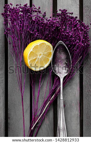LEMON WITH ANTIQUE SPOON WITH DRY FLOWERS ON BLACK AND WHITE BACKGROUND