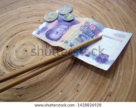 Chinese money and business markets changes. Chinese Yuan, Banknotes and coins on plate with chopsticks. Chinese money and political situation.