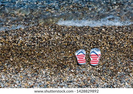 A pair of beach color slippers by the sea