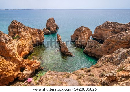 Landscape photo of a view of the Portugal coast with big cliffs and turquoise waters. Shot in the Faro district  in the Algarve, Portugal. 