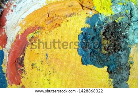 Close-up with oil paint strokes on canvas. Multicolored rough spots on an orange background.