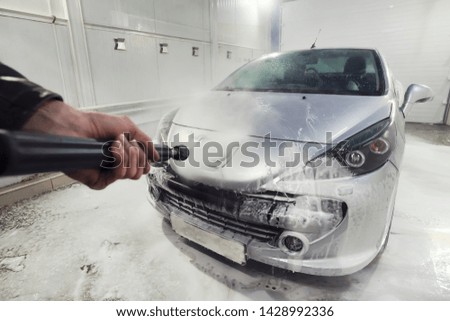 Cleaning sport Car Using High Pressure Water. Man washing his car under high pressure water in service. man worker washes the car. self-service