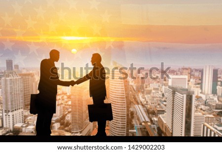 Double exposureTwo businessmen are shaking hands with each other standing against panoramic urban of city on national flag backgroung,copy space.