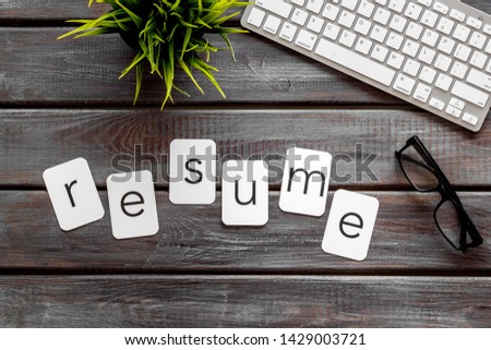Resume copy on work place with keyboard and glass on wooden desk background top view