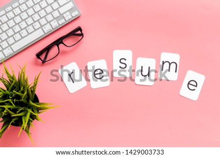 Resume copy on work place with keyboard and glass on pink desk background top view