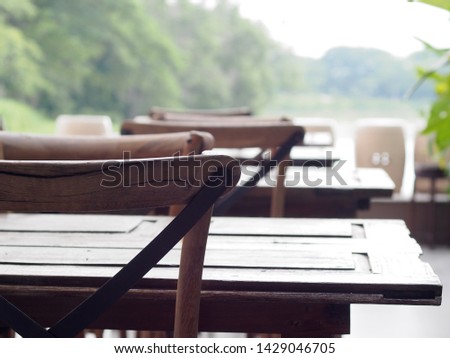 old rough grunge wooden chairs and table crop closeup in on tropical style cafeteria terrace with green environment blur behind for use as relax mood picture backdrop or background