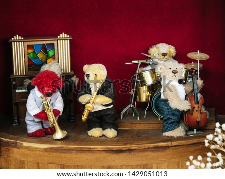 The band, teddy bear, playing music, saxophone blowing, drumming, playing piano and playing cello