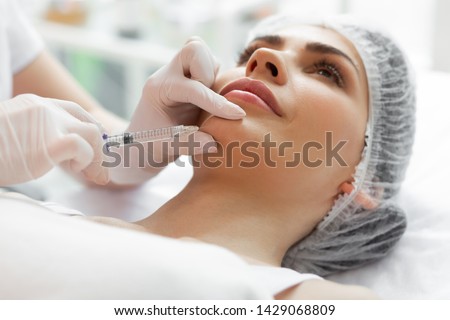 Chin injection. Close up of a female face during the injection in the chin