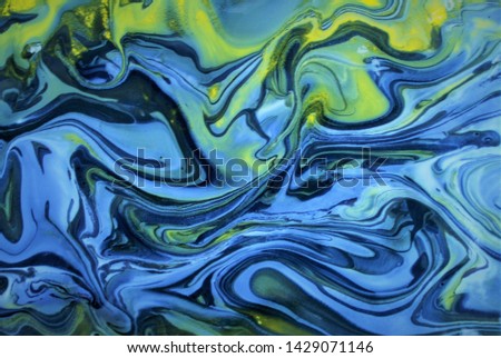 Abstract colorful background.Yellow and blue acrylic paints flow freely, forming an interesting structure. Cool shades.Good for book, magazine, catalog cover and design, fabric.