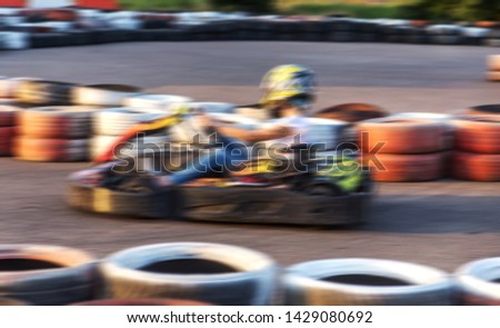 Strong motion blur karting. The picture is out of focus. Racers on races on special safe high-speed tracks limited by car tires. Attraction High-speed ride in carts. Sport karting entertainment
