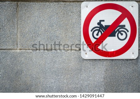 Motorcycle no entry sign install on concrete wall in front of tunnel under road. Traffic sign to prohibit motorcycle. Restrictive signs. Motorcycle caution and stop driving to this way. Ban motorbike 