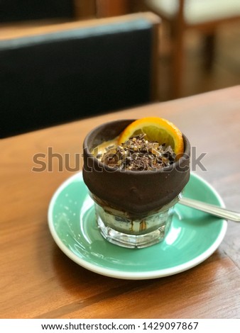 Affogato coffee serve with chocolate ice cream and orange in a glass coated with chocolate, closeup