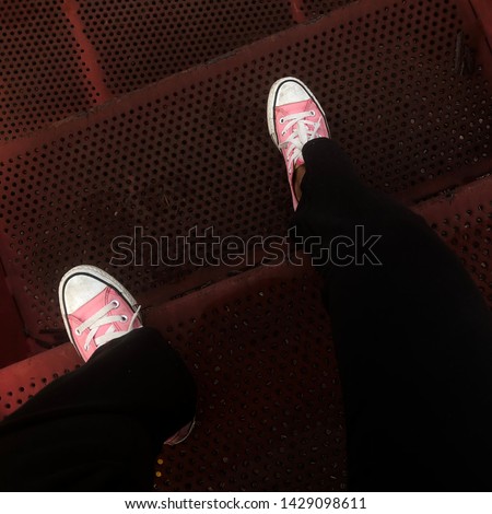 Pink sneakers on red stairs