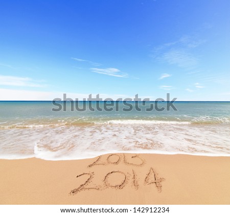 New Year 2014 is coming concept - inscription 203 and 2014 on a beach sand, the wave is covering digits 2013 Royalty-Free Stock Photo #142912234