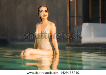 Portrait young beautiful asian woman happy smile and relax in swimming pool around hotel resort for leisure travel in holiday vacation