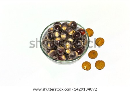 A bowl full of peeled longan fruit and some unpeeled longan on white background.top view.