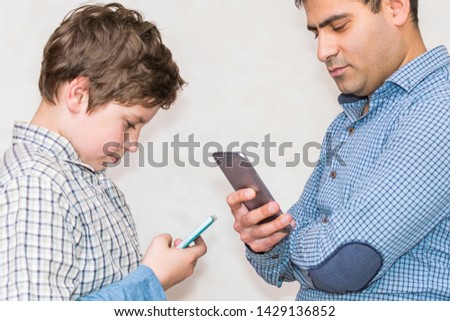 problems in communication with the child. father and son look at the phone separately