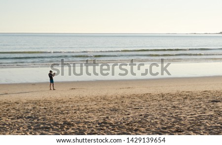 Man taking pictures at sunset on A Lanzada beach, O Grove, Galicia.