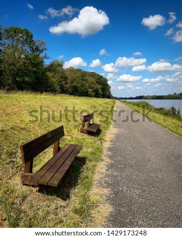 Two benches at the side of the lake. Picture taken in Willebroek, Belgium. 