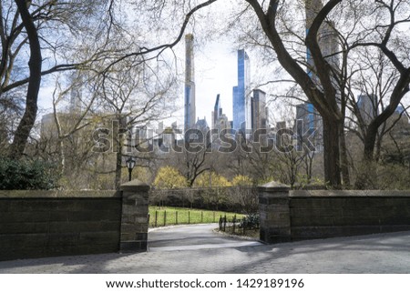 Panoramic landscape view over Central Park entrance and its trees without leaves at the end of winter, early of spring, buds on branches, skyscrapers, Manhattan, nyc, New York city, America, USA.