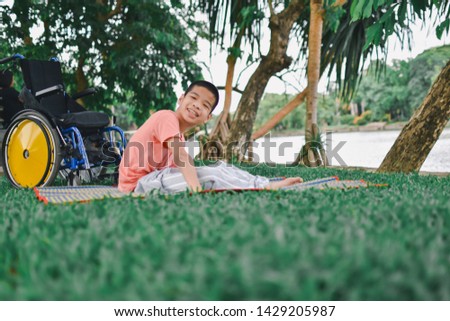 Disabled child is doing physical in the park, Wide garden makes him ready to practice, Special children's lifestyle, Life in the education age of special need children, Happy disability kid concept.