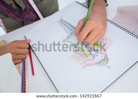 Man drawing clothes for women