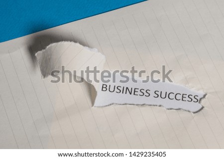 The business word Business Success written on vintage paper. Top view. Torn paper revealing the word. Innovation and ideas