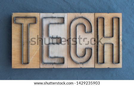Old wood and steel number plate dies spell out the word TECH