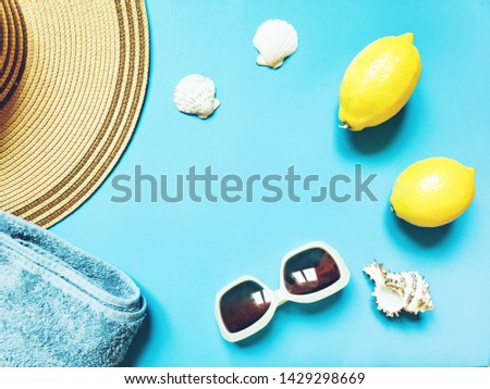 Beach holidays in Greece. Close-up picture of women's sun hat, towels, sunglasses, lemons and seashells. Flat lay composition photo, mockup, free space for text