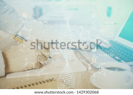 DNA hologram with businessman working on computer on background. Concept of bioengineering. Double exposure.