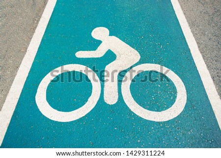 Separate bicycle lane for riding bicycles.Bicycle icon on the lane .New public asphalt bicycle lane  close up beside the road.White painted bike on asphalt.