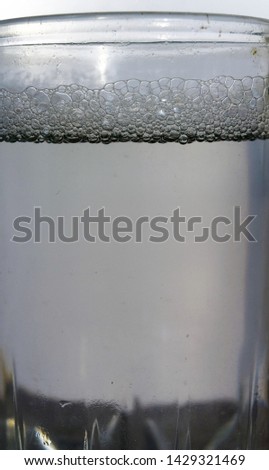 Photograph of a background with bubbles in a liquid in a glass beaker