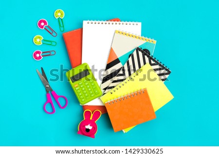 Stationary, back to school,summer time, creativity and education concept.School supplies - dividers, pencils, paper clips,note,stapler and notepad, globe on blue background, flat lay. Mock up.Top view