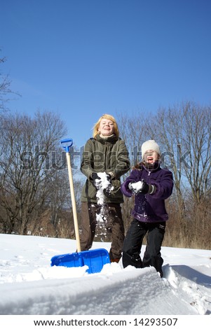 mother and her daughter throw up snow on a winter background