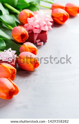 Spring background with orange colorful tulips and gift box, women, mother day, greeting card, copy space image