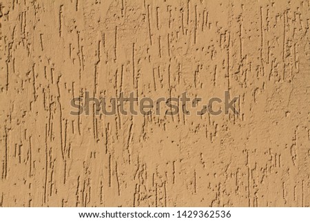 Brown decorative plaster imitating damage to wood by bark beetle