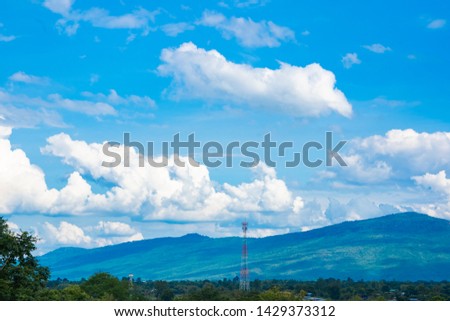 Sky blue or azure sky and clouds over forest hills or mountain. Everything lies above surface atmosphere outer space is sky. Cloud is aerosol comprising visible mass of liquid droplets frozen in air.