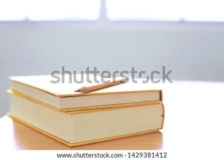 Backlit of books stacked on the desk selective focus and shallow depth of field