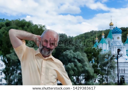 Portrait of a man in a light yellow shirt standing on the river embankment against the background of the Church of Svyatogorsk Lavra