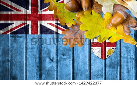 Fiji flag on autumn wooden background with leaves and good place for your text.