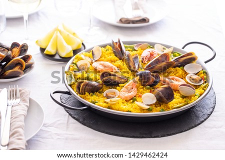 
Seafood Paella with  prawns, clams, mussels on saffron rice and vegetables served in  traditional frying pan. Paella de marisco Spanish cuisine background
