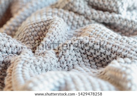 Abstract of a soft knit grey throw blanket with selective focus in center
