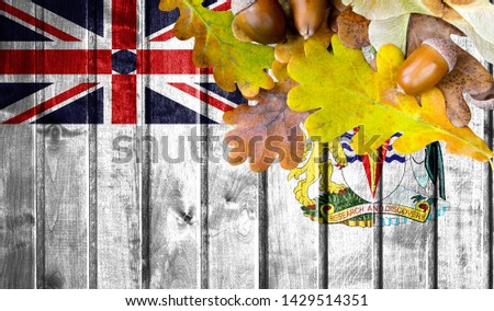 British Antarctic Territory flag on autumn wooden background with leaves and good place for your text.